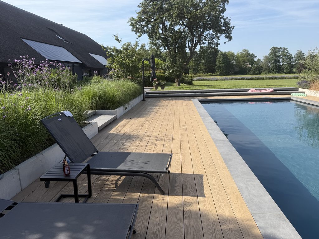 Zonneterras met Millboard-vlonders, zwembad en verhoogde borders