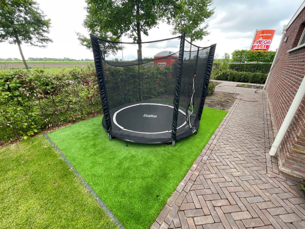 Aparte plek voor de trampoline naast het gazon