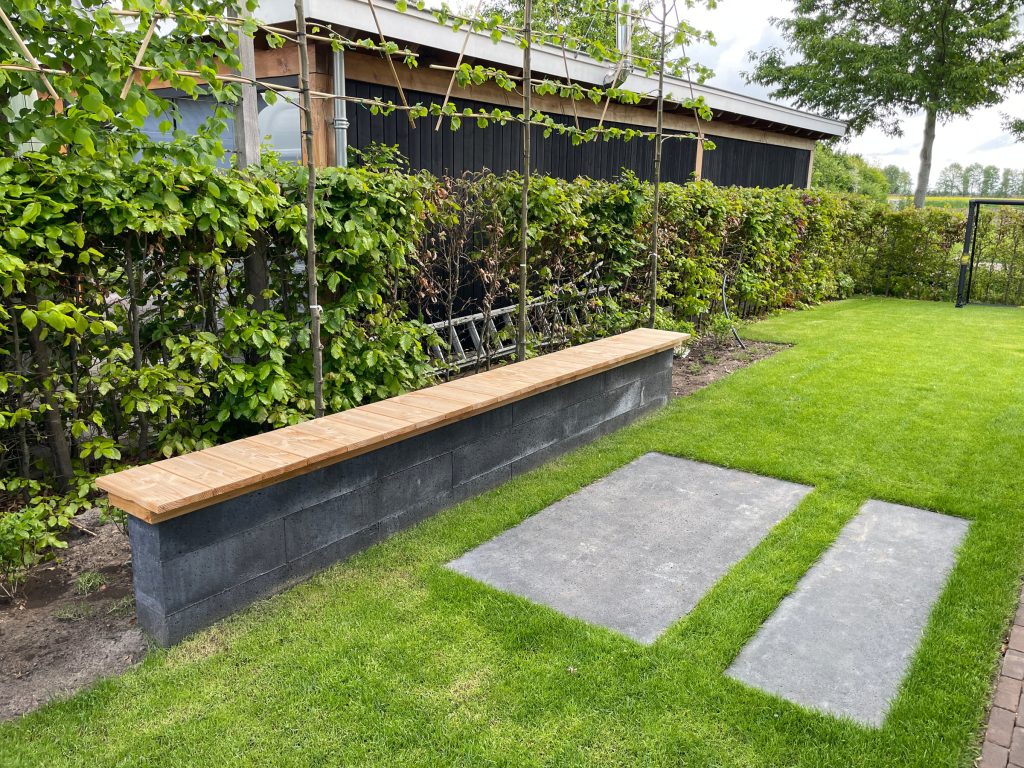 Maatwerk zitmuur met houten zitting en staptegels
