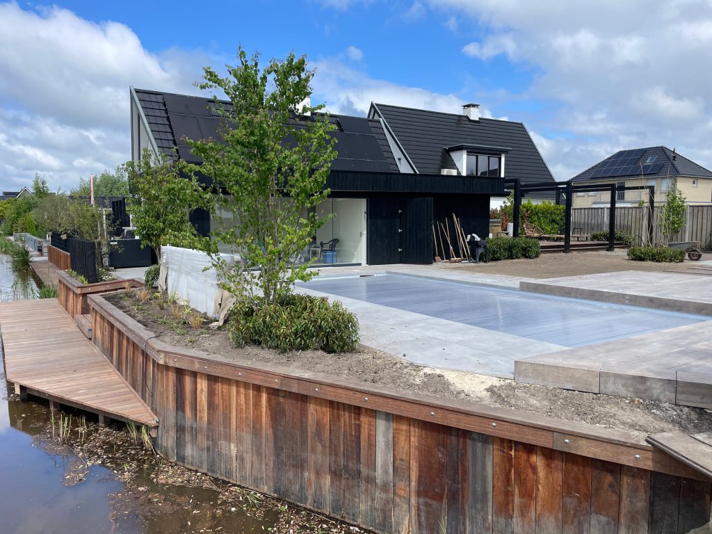 Nieuwe houten beschoeiing langs de complete wellnesstuin
