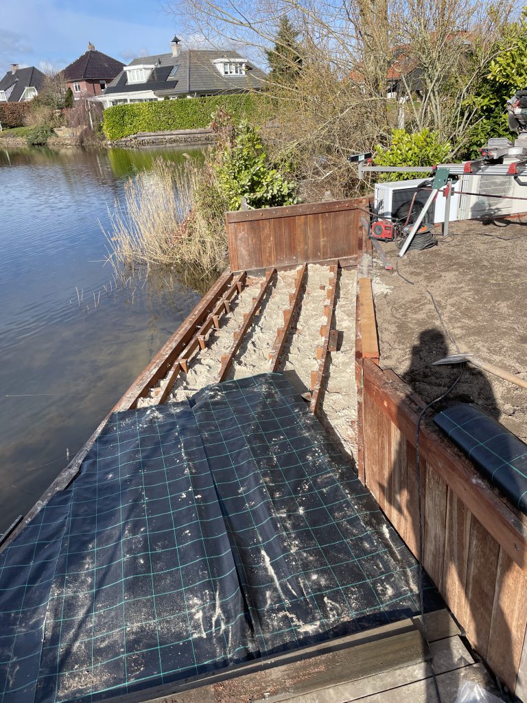 Onderconstructie van een houten vlonder langs een nieuwe beschoeiing