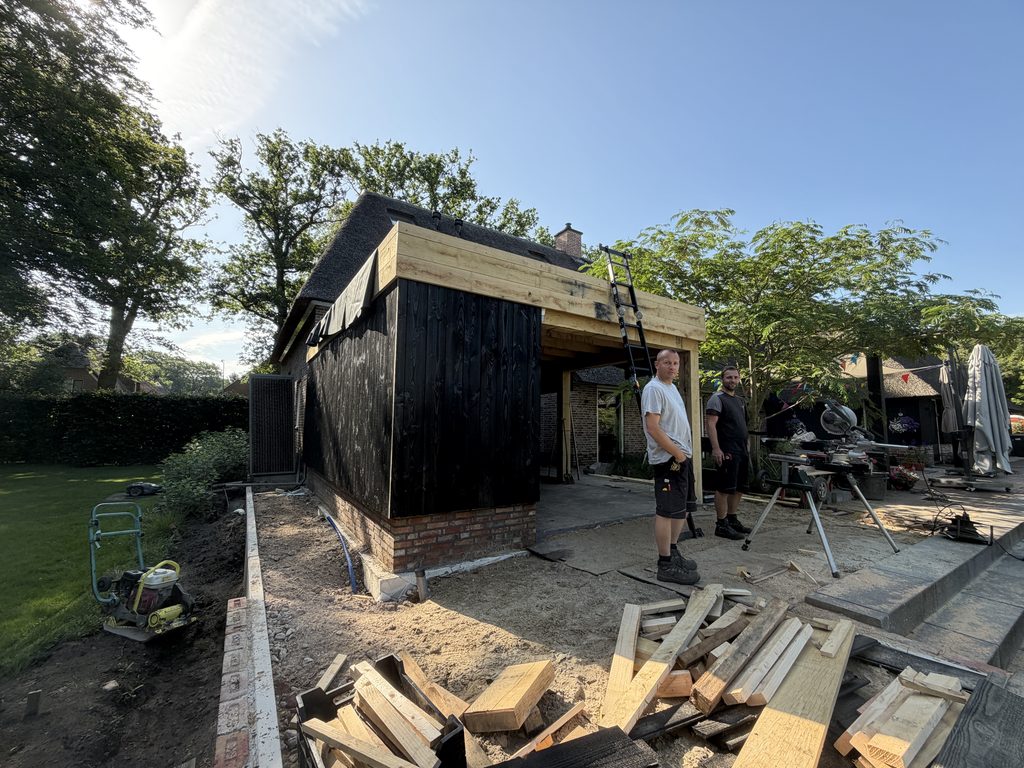 Tuinkamer in aanbouw met zwarte houten gevelbekleding
