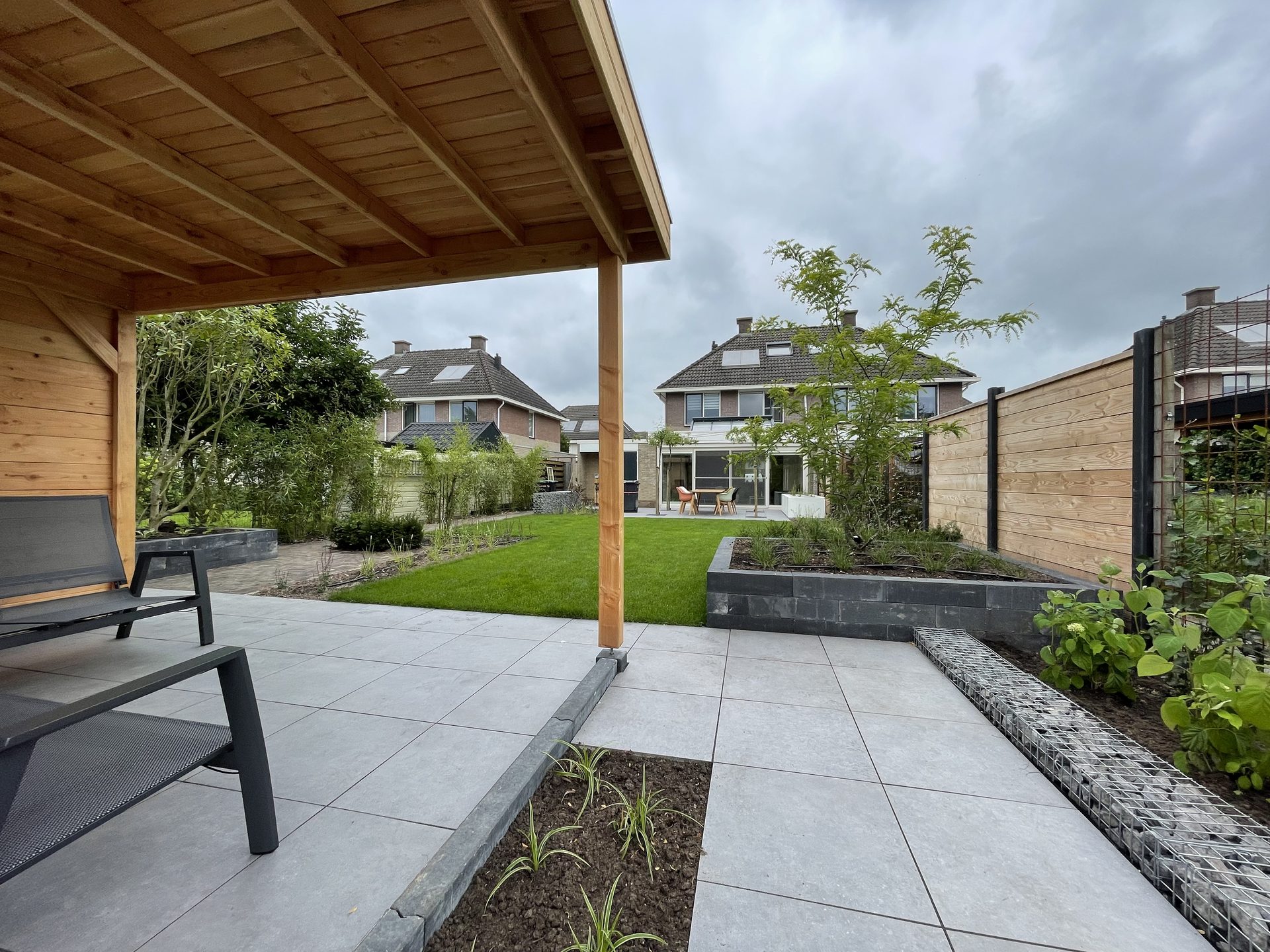 Gerealiseerde achtertuin met tuinhuis, terras en gazon in Coevorden