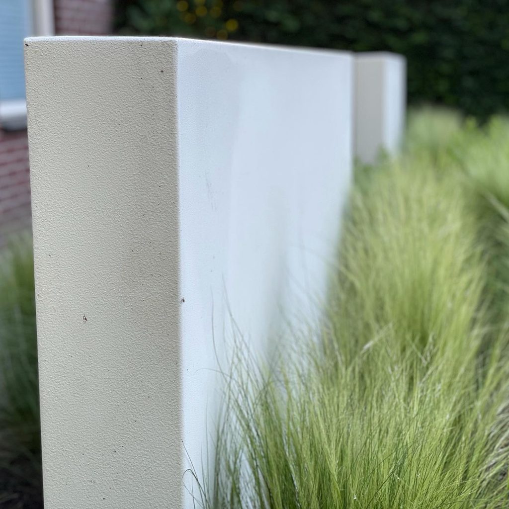 Detail van een witte Luxcom maatwerk plantenbak tussen siergrassen