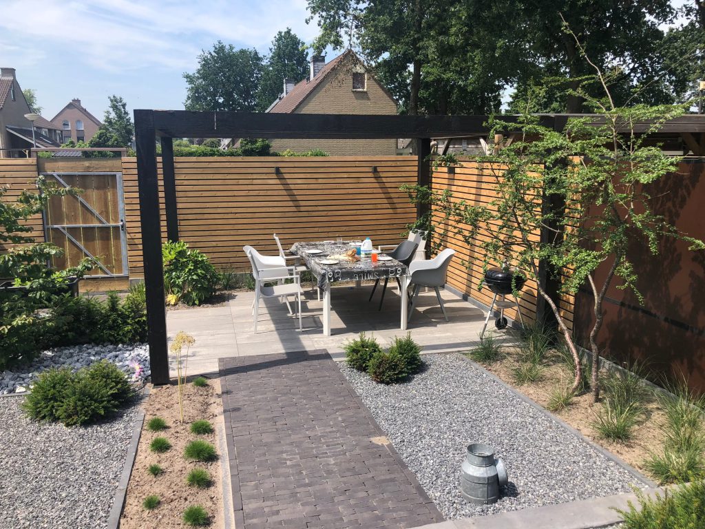 Horizontale houten schutting rond een terras met pergola