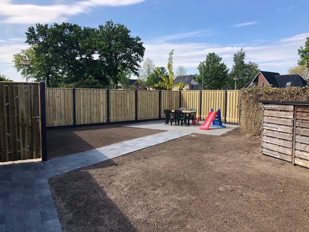 Houten schutting met donkere betonpalen en bijpassende poort