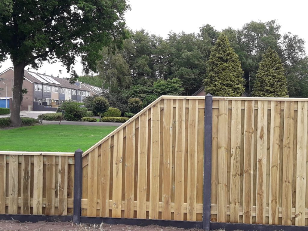 Houten tuinafscheiding op verschillende hoogtes met donkere palen