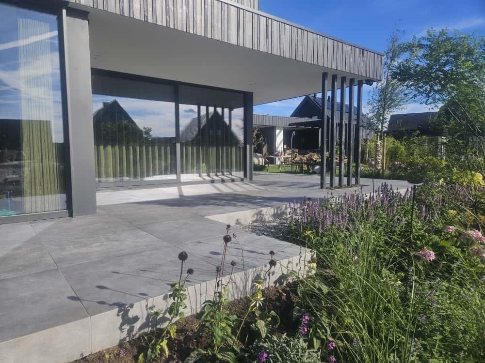 Keramisch terras met maatwerk randen en bloeiende beplanting