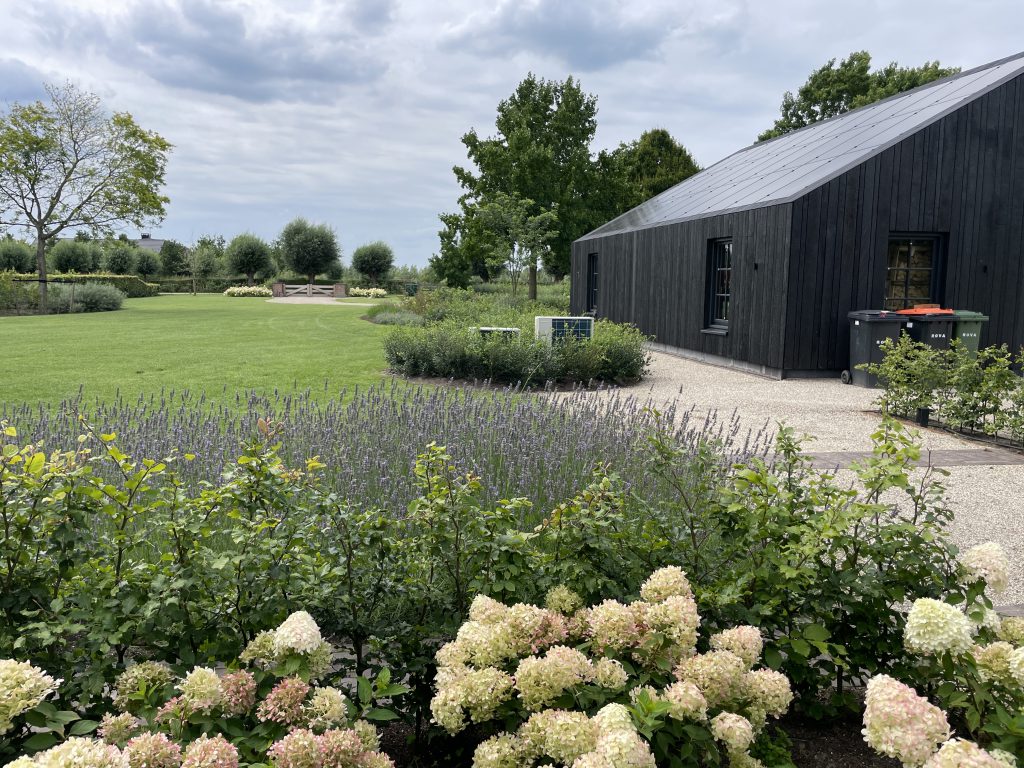 Royaal gazon en bloeiende beplanting rondom de villa in Zwolle