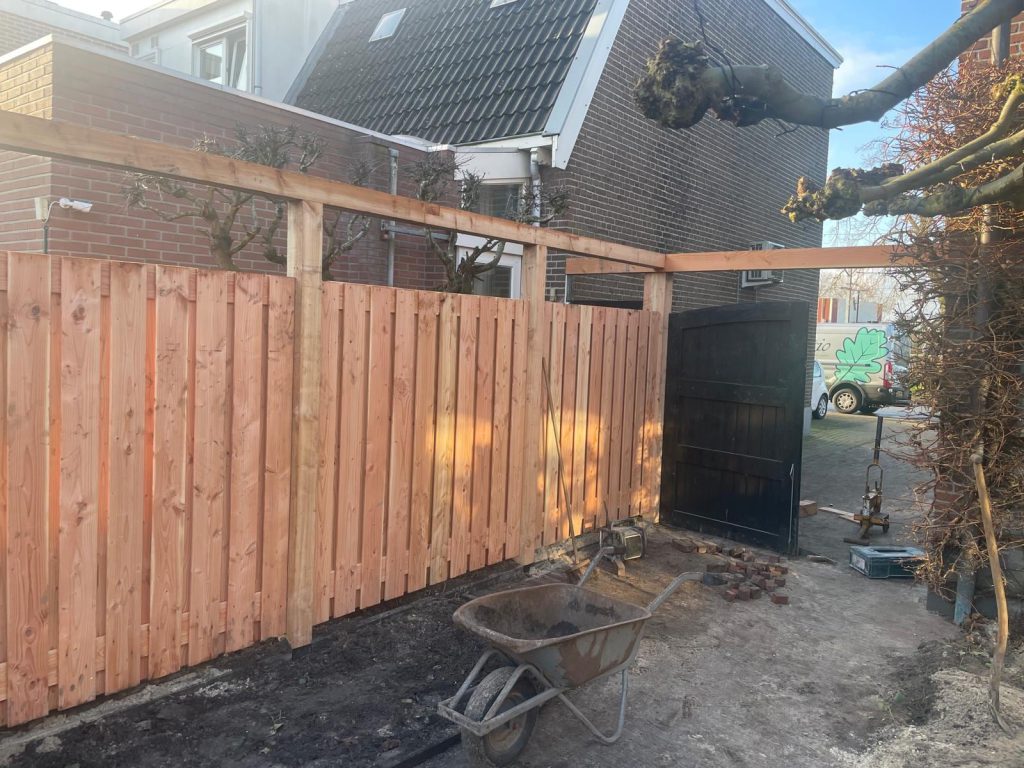 Houten tuinafscheiding met maatwerk poort en pergolabalk