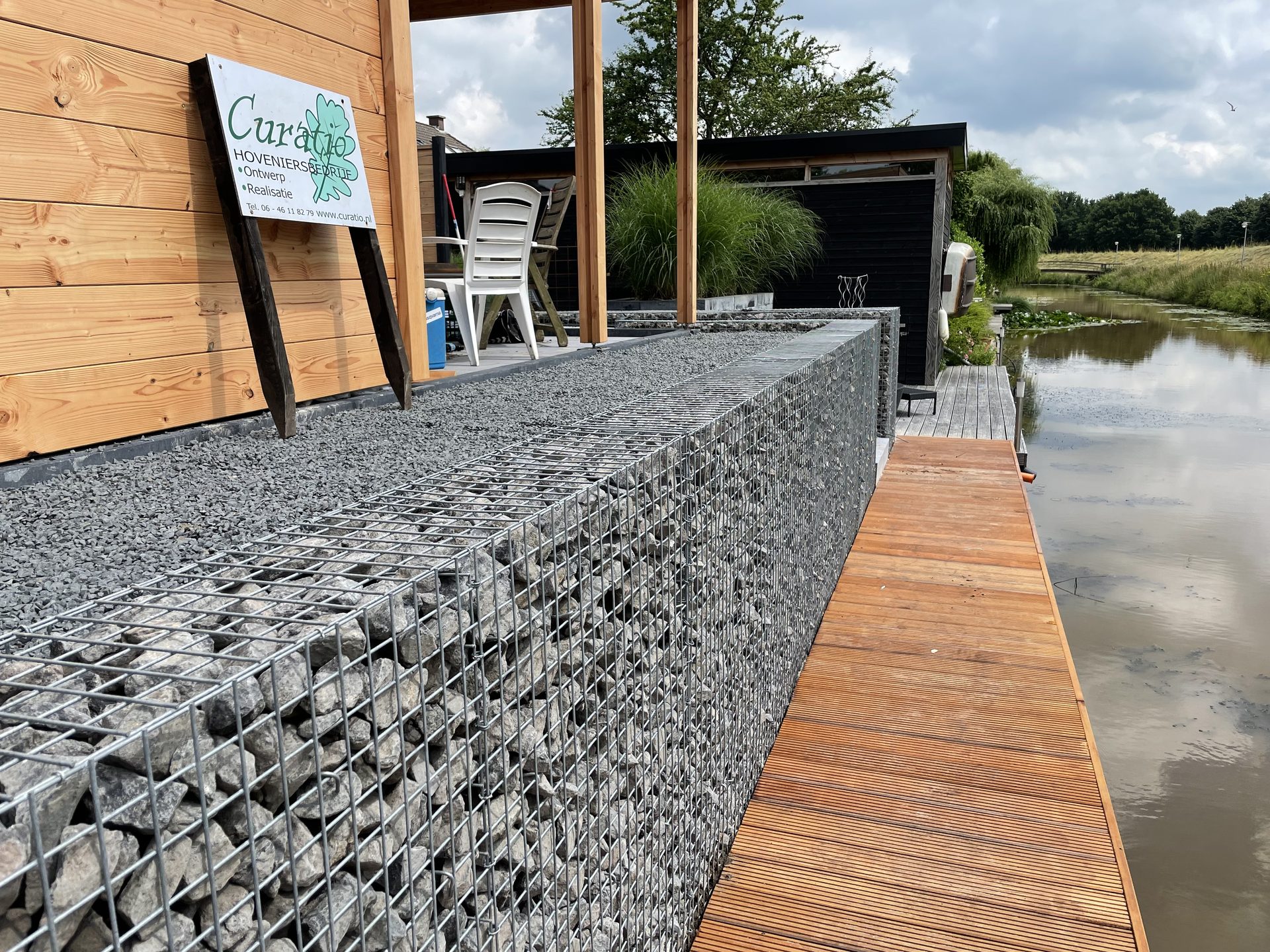 Schanskorven en hardhouten vlonder langs het water