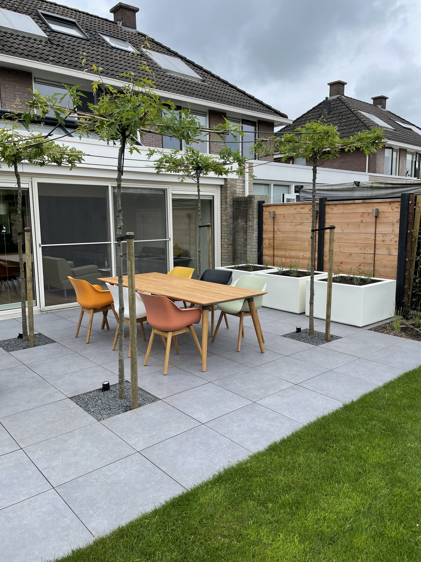 Keramisch terras met dakbomen en witte plantenbakken