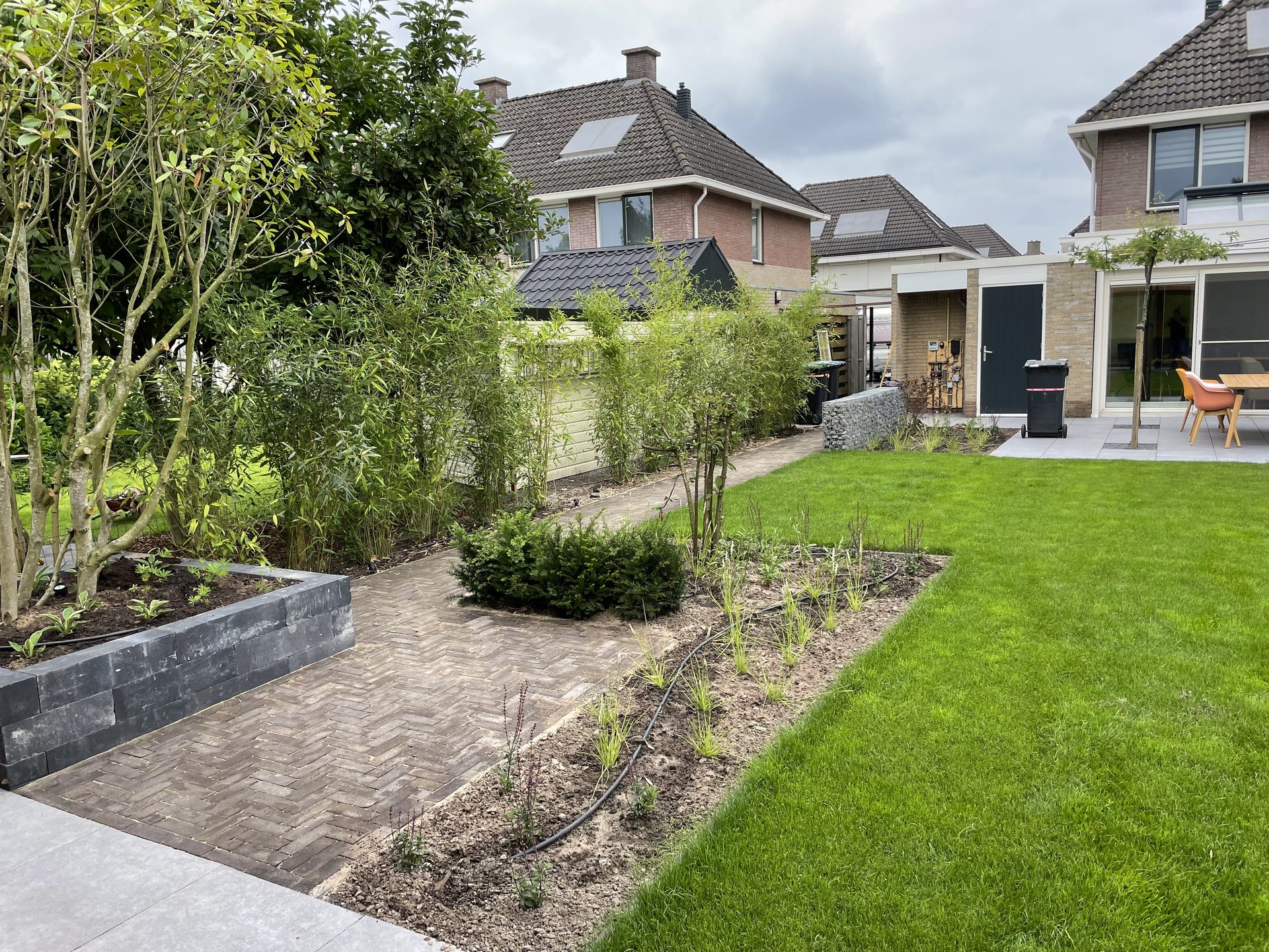 Gebakken tuinpad met nieuwe beplanting in de achtertuin