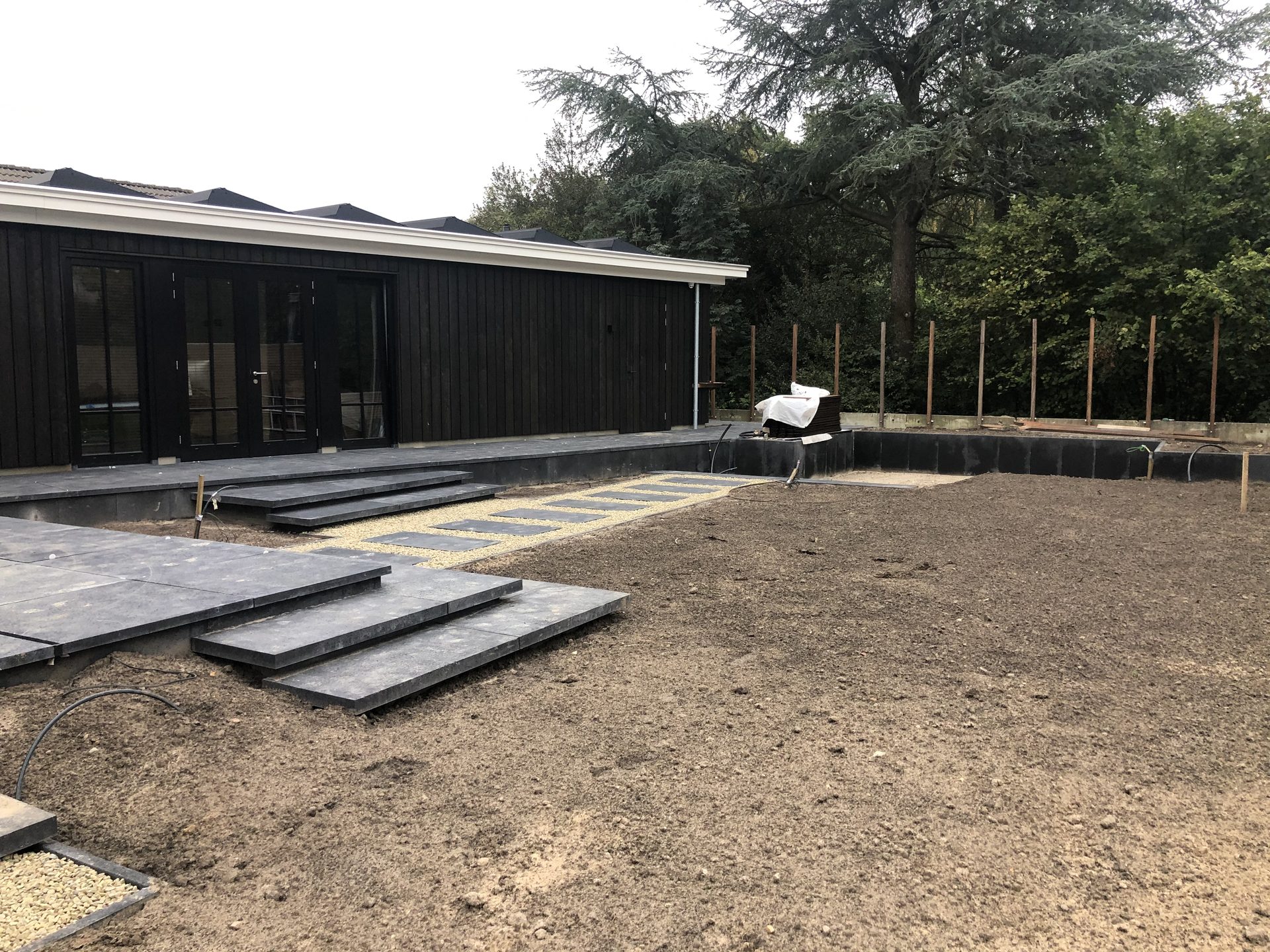 Voorbereide tuinvakken rond de terrassen van de villatuin