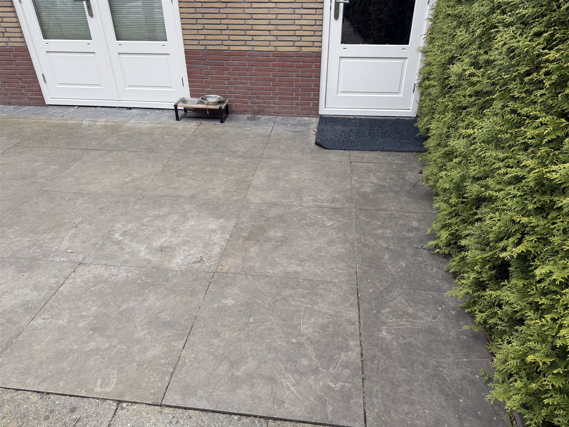 Verouderde Chinese hardstenen bestrating bij de woning in Ommen